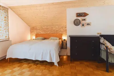 a bedroom with a bed and a wooden floor at Apartma Saša in Zgornje Jezersko