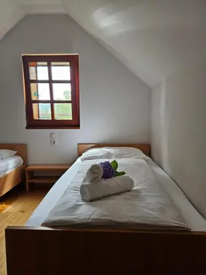 a bed with two towels and a window in a room at Mežnarija - Cerovec in Dolenjske Toplice