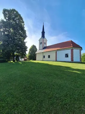 a church with a grass field in front of it at Mežnarija - Cerovec in Dolenjske Toplice