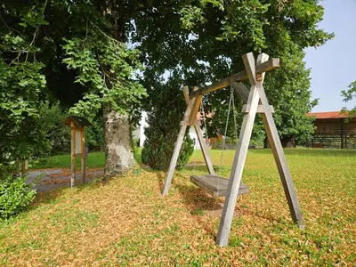 a swing set in a park with a tree at Mežnarija - Cerovec in Dolenjske Toplice