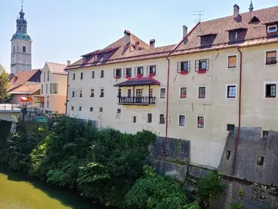 an old building next to a river in a city at Hotel garni Paleta in Škofja Loka