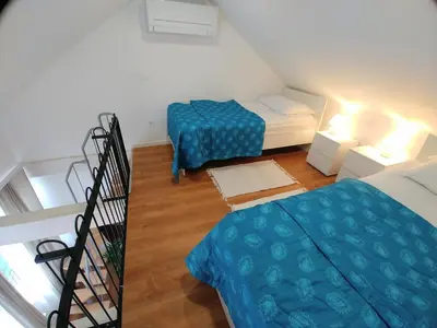 a small room with two beds and a staircase at Hotel garni Paleta in Škofja Loka