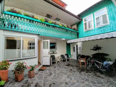 a house with a balcony and a bike parked outside at Hotel garni Paleta in Škofja Loka
