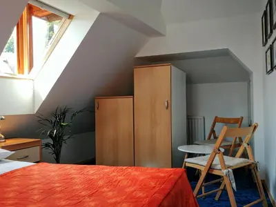 a bedroom with a bed and a table and a cabinet at Hotel garni Paleta in Škofja Loka