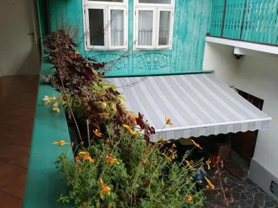 a blue building with a white bench on a balcony at Hotel garni Paleta in Škofja Loka