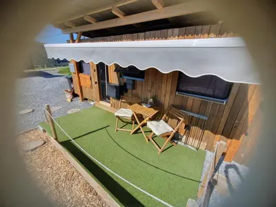 a building with a table and chairs on a green lawn at Tepe Retreat in Konjšica