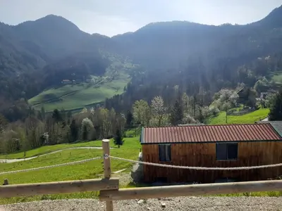 a wooden house on a hill with a fence at Tepe Retreat in Konjšica