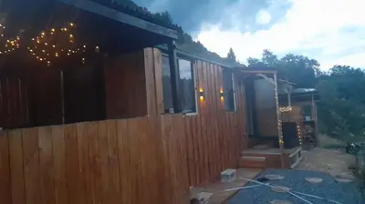 a wooden cabin with a fence in front of it at Tepe Retreat in Konjšica