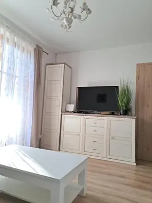 a white living room with a tv and a table at Mountain spring in Kranjska Gora