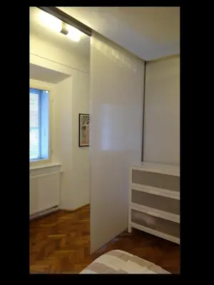 a bedroom with white walls and a window at Domus Romanus in Ljubljana