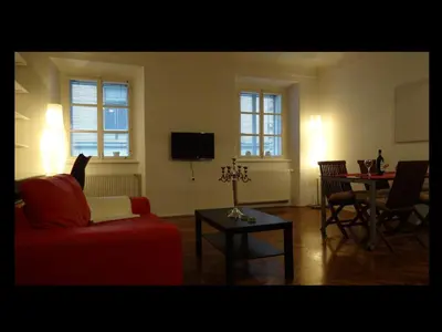 a living room with a red couch and a table at Domus Romanus in Ljubljana