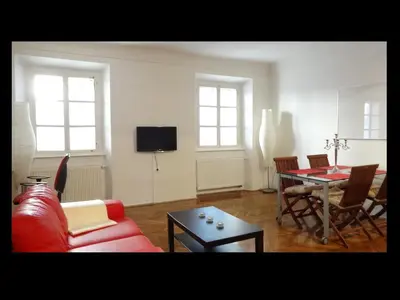 a living room with a red couch and a table at Domus Romanus in Ljubljana
