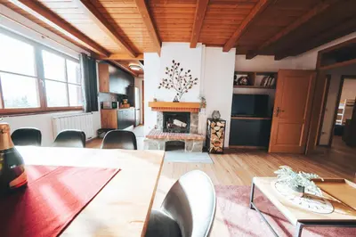 a living room with a table and a fireplace at Apartment Bolfenk Pohorje - Forest nest in Pohorje