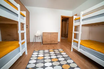 a bedroom with two bunk beds and a rug at Apartment Bolfenk Pohorje - Forest nest in Pohorje