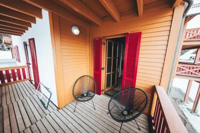 two chairs sitting on the front porch of a house at Apartment Bolfenk Pohorje - Forest nest in Pohorje