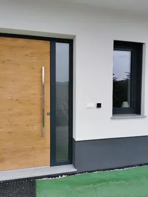a wooden door on a building with two windows at Apartma Gaber in Veliki Gaber