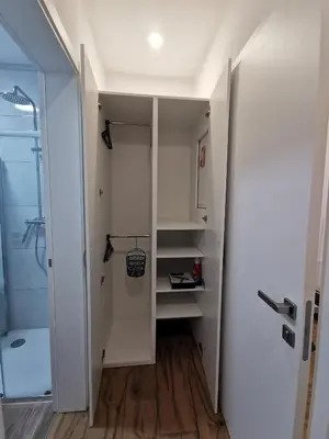 a walk in closet with white cabinets and a shower at Apartma Gaber in Veliki Gaber
