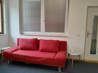 a red couch in a room with a window at Apartma Dea in Nova Gorica