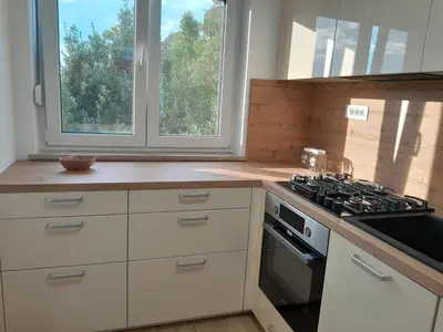 a kitchen with a stove top oven next to a window at Apartma Dea in Nova Gorica