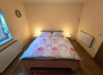 a bedroom with a bed with pink flowers on it at At Granny's in Maribor