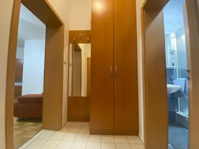 a bathroom with wooden cabinets and a mirror at Apartma ROGATEC 2 in Rogatec