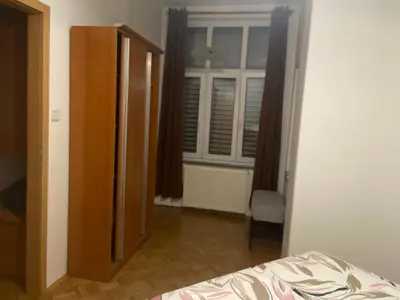 a bedroom with a bed and a window and a chair at Apartma ROGATEC 2 in Rogatec
