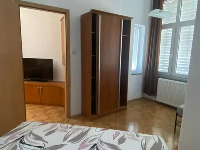 a bedroom with a bed and a cabinet with a television at Apartma ROGATEC 2 in Rogatec