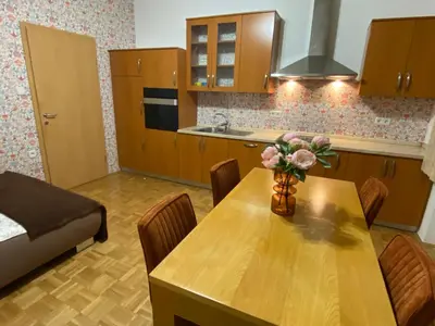 a kitchen with a wooden table with a vase of flowers on it at Apartma ROGATEC 2 in Rogatec