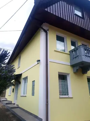a yellow and white house with a balcony at Apartma Suzy in Bovec