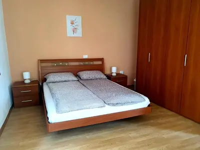 a bedroom with a bed with two night stands and two cabinets at Apartma Suzy in Bovec