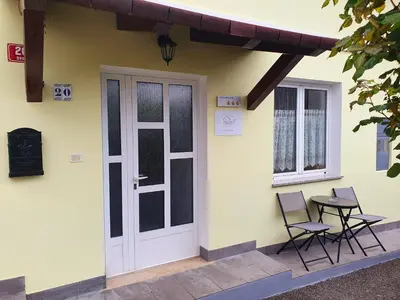 a house with two chairs and a door and a table at Apartma Suzy in Bovec