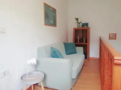 a living room with a white couch and a chair at Apartma Suzy in Bovec