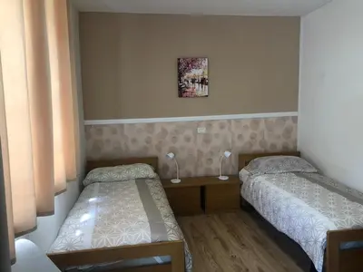 a bedroom with two beds and a table with lamps at Apartma Suzy in Bovec