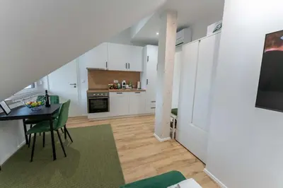 a kitchen with white cabinets and a table and a dining room at GOLDEN OASIS Free Private Parking in Ljubljana