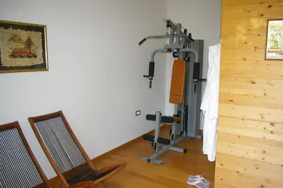 a room with a gym with a treadmill and two chairs at Vila Katarina in Hrastenica