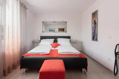 a bedroom with a bed with a red ottoman at Apartment MaLa in Bled