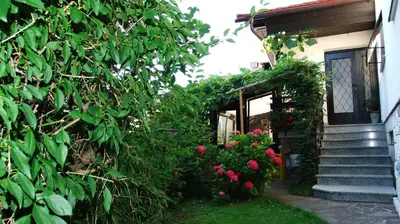 a house with a staircase and flowers in front of it at Apartment MaLa in Bled