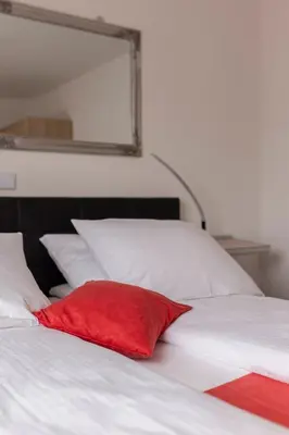 a red pillow sitting on top of a white bed at Apartment MaLa in Bled