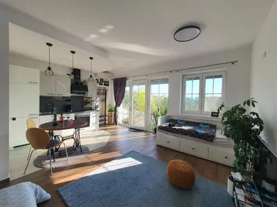 a large living room with a table and a kitchen at Apartma Tomažič in Hrušica