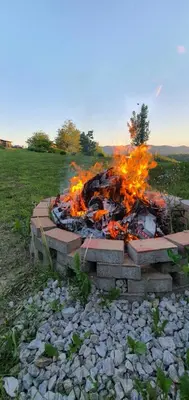 a fire pit in the middle of a field at Apartma Tomažič in Hrušica