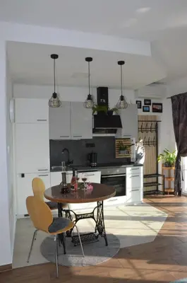 a kitchen with a table and chairs in a room at Apartma Tomažič in Hrušica