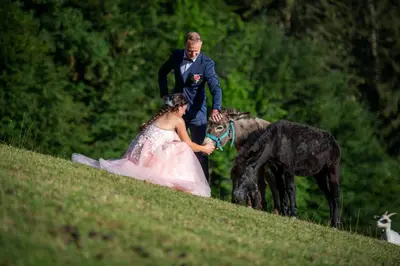 a bride and groom walking down a hill with a dog at Domačija Za robom in Cerkno