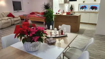 a living room with a table with flowers on it at Apartments Akacijev Izvir in Miklavž na Dravskem Polju