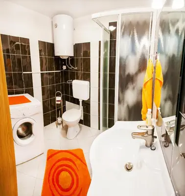 a bathroom with a sink and a washing machine at Apartments Shock in Cerkno