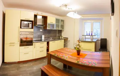 a kitchen with a wooden table and a dining room at Apartments Shock in Cerkno
