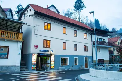 a white building with a red roof on a street at Apartments Shock in Cerkno