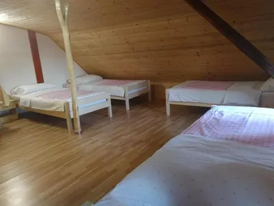 a attic room with three beds and wooden floors at Farm Stay Pr Lavric in Slivna