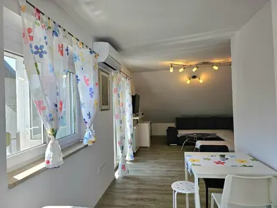 a living room with a table and a window at Green Hill Apartments in Žirovnica