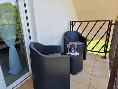 a couple of black chairs sitting next to a window at Green Hill Apartments in Žirovnica