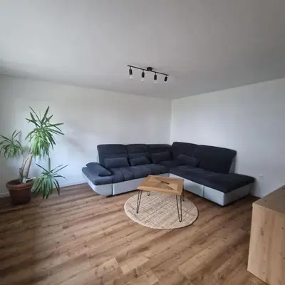 a living room with a blue couch and a coffee table at Apartment Little Heaven in Zbilje